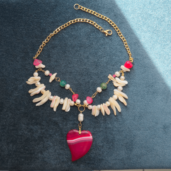 Flat lay of the Heart of Nature necklace on blue velvet background