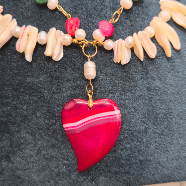 Close-up of deep pink agate heart pendant centerpiece