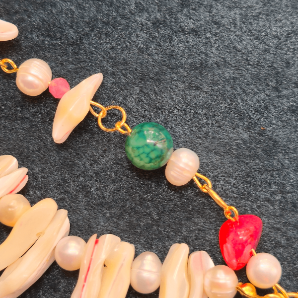Macro view of green tourmaline and pink stone with mother-of-pearl