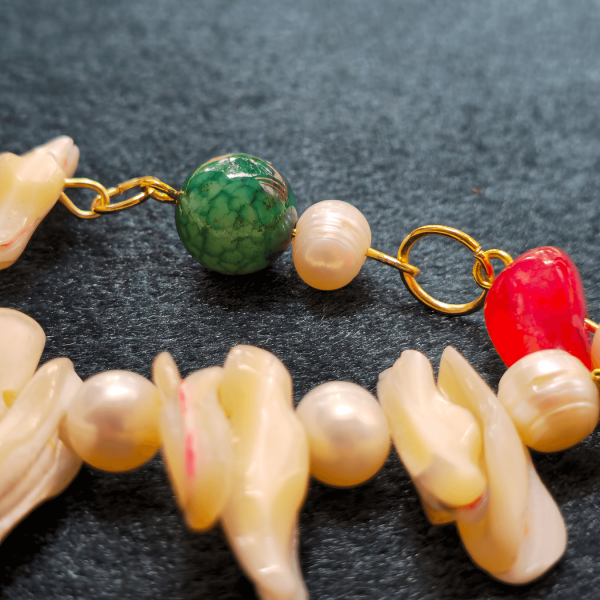 Zoom on green tourmaline and freshwater pearls connected with gold link